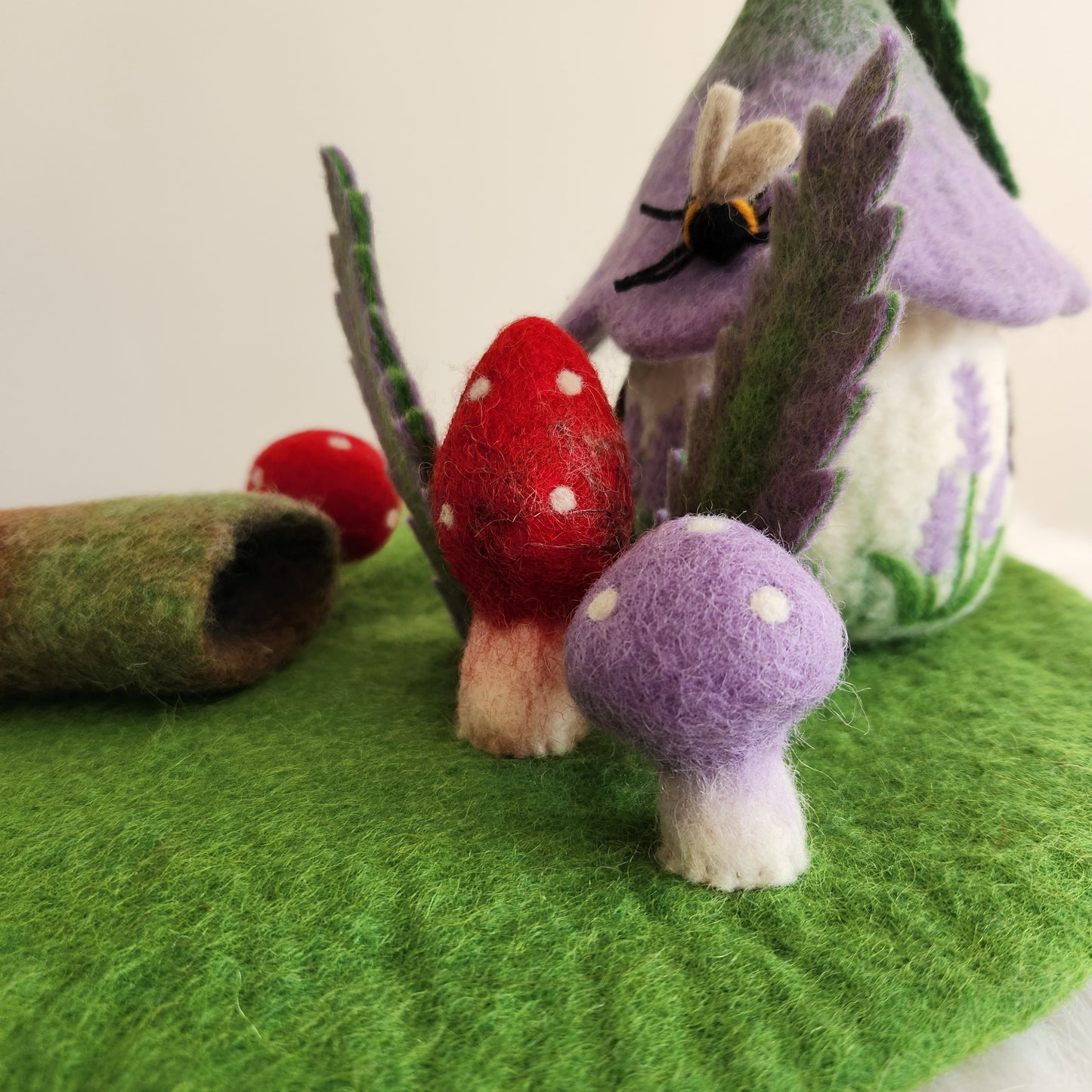 FOREST FLOOR STORYTELLING PLAYMAT - GREEN FELT PLAYMAT WITH ATTACHED MUSHROOMS, FERNS AND A HOLLOW LOG.