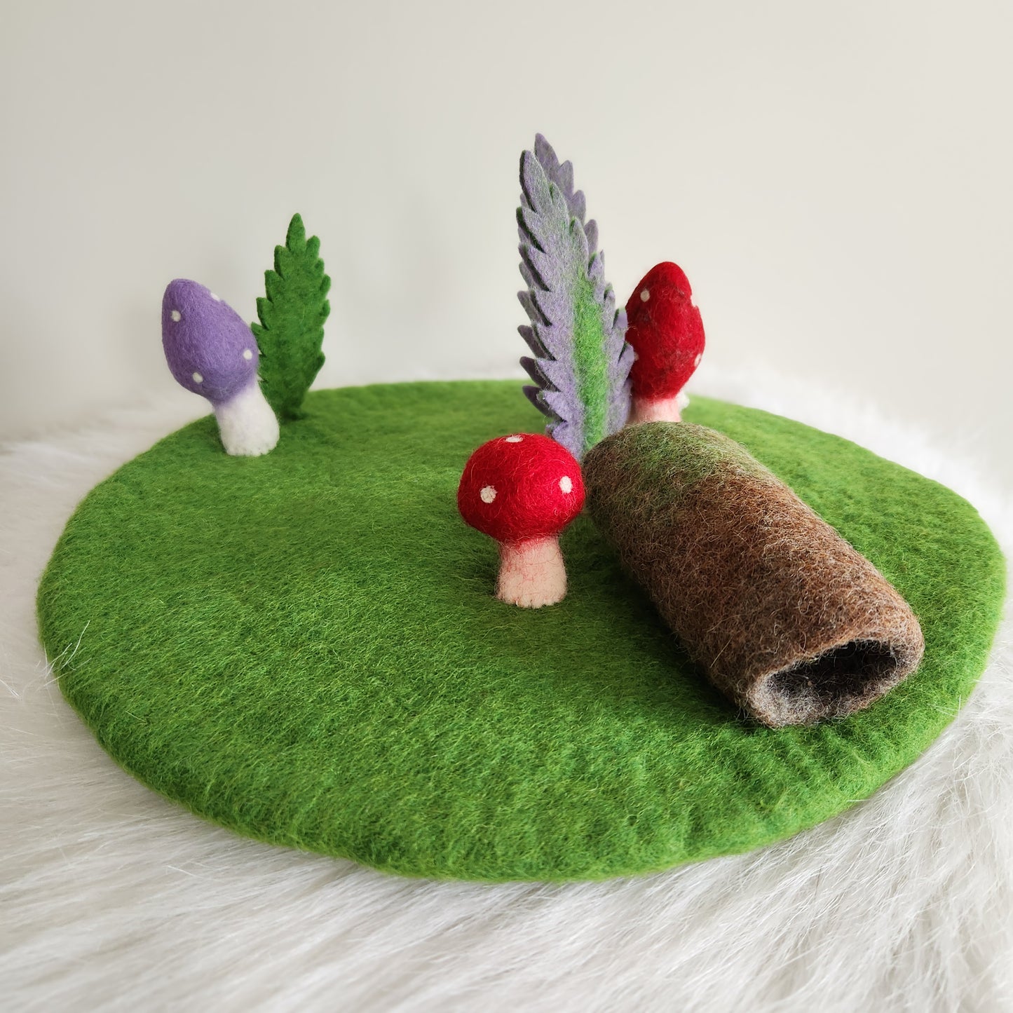 FOREST FLOOR STORYTELLING PLAYMAT - GREEN FELT PLAYMAT WITH ATTACHED MUSHROOMS, FERNS AND A HOLLOW LOG.