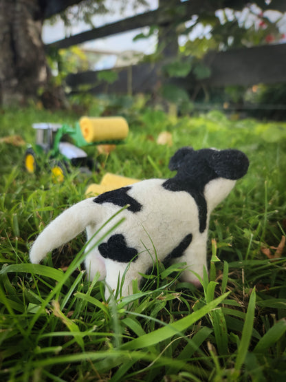 Candice the Calf - Felted Cow Toy in grass paddock with toy tractor