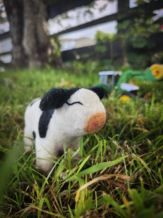 Candice the Calf - Felted Cow Toy in grass paddock with John Deere toy tractor in background