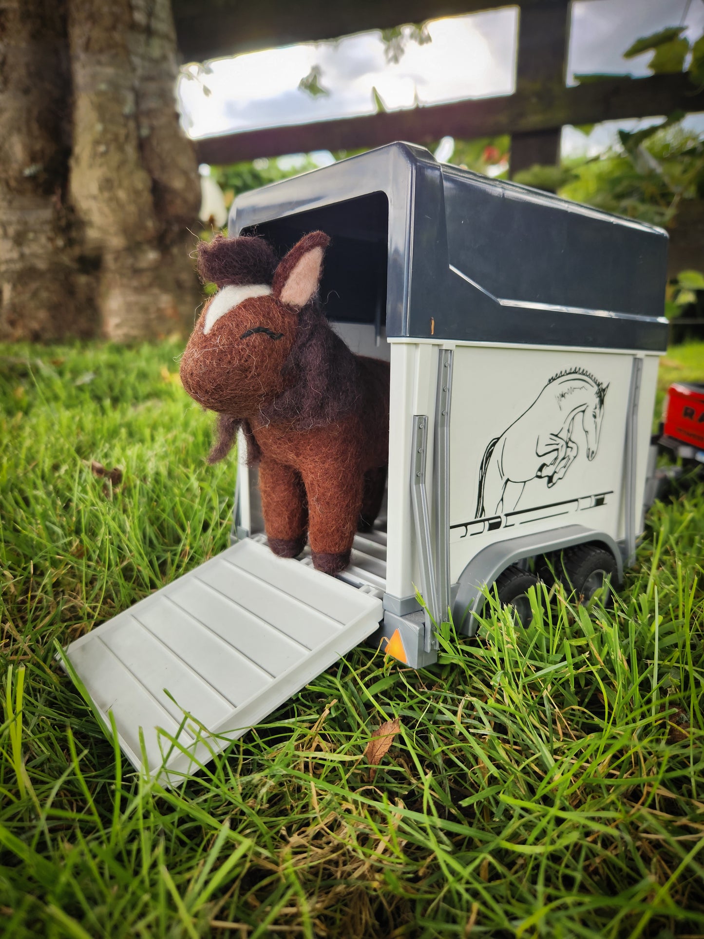 Hamilton the Horse - Felt Toy Horse outside in grass paddock with horse float toy