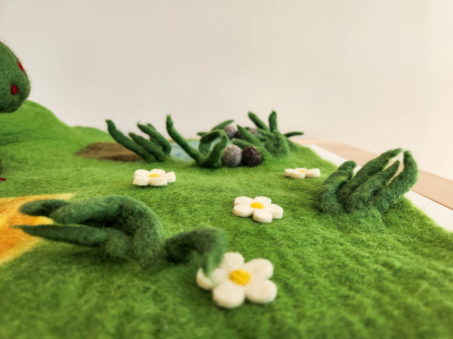 Happy Hooves - Felt Farmyard Play Mat close up view of daisy field, grass and duck pond in background