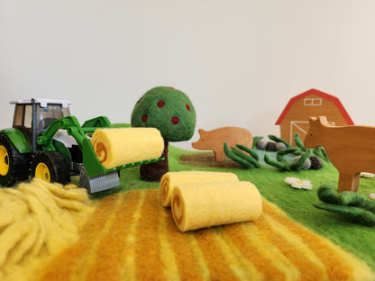 Happy Hooves - Felt Farmyard Play Mat close up of hay field with toy tractor and wooden animals