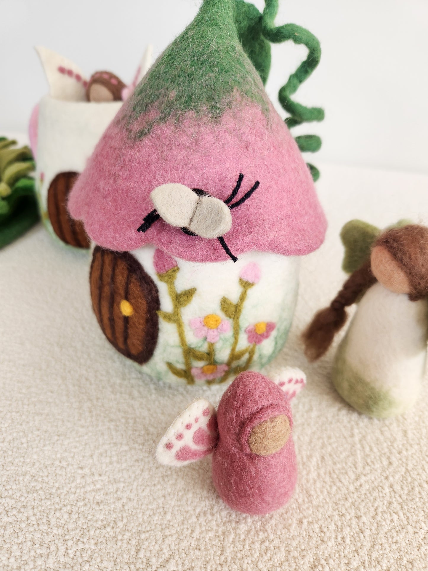 BELLFLOWER BUNGALOW FELT FAIRY HOUSE WITH DUSTY ROSE COLOURED FLOWER TOP. ROOF AND FLORAL VINE DETAILS WITH FAIRIES IN FOREGROUND