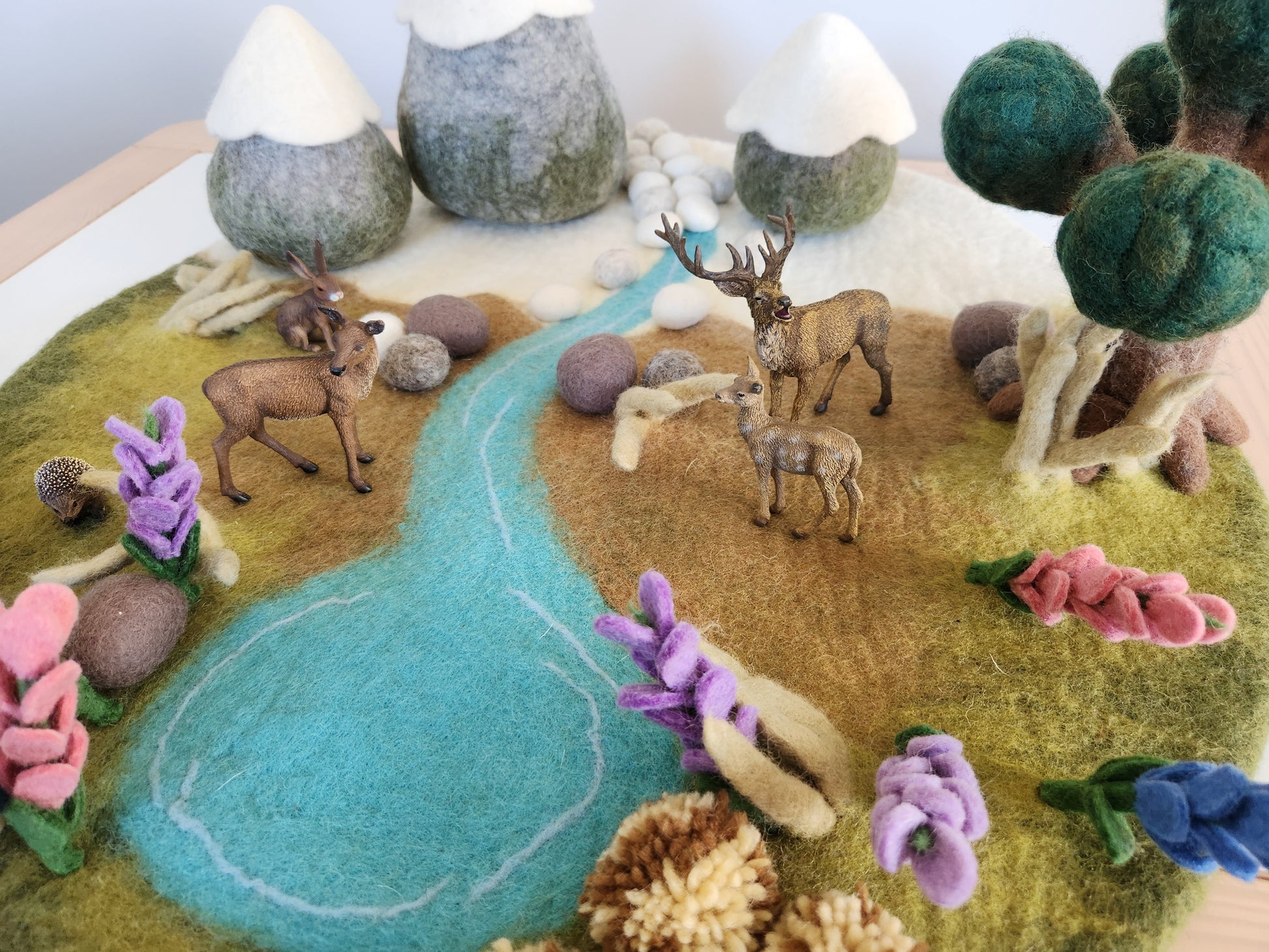Felted landscape with deer, tree, and flowers on a felted base