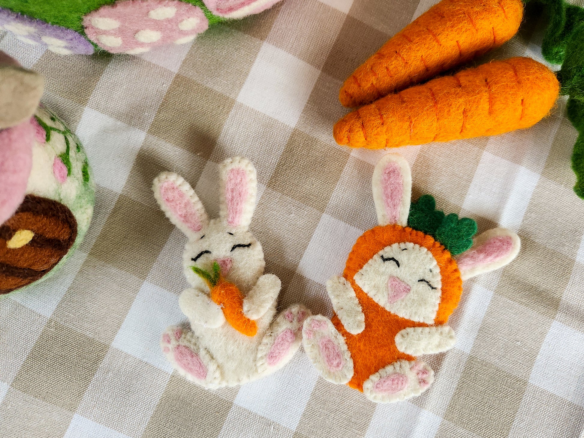 Wool Felt Bunny and Bunny in Carrot Costume Finger Puppets on table with felt carrots