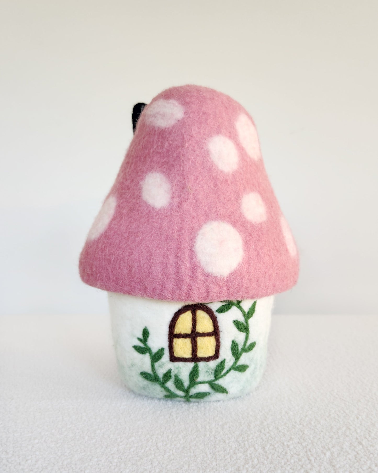 Fairy house with pink polka dot roof on a white background