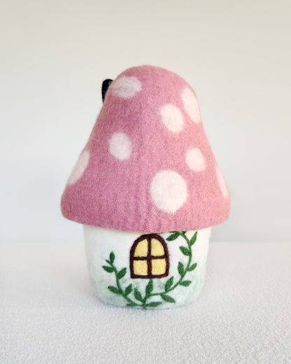Fairy house with pink polka dot roof on a white background