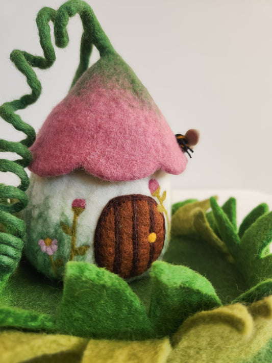 MEDIUM BELLFLOWER BUNGALOW FELT FAIRY HOUSE WITH DUSTY ROSE FLOWER TOP SITTING ON GRASSY MAT