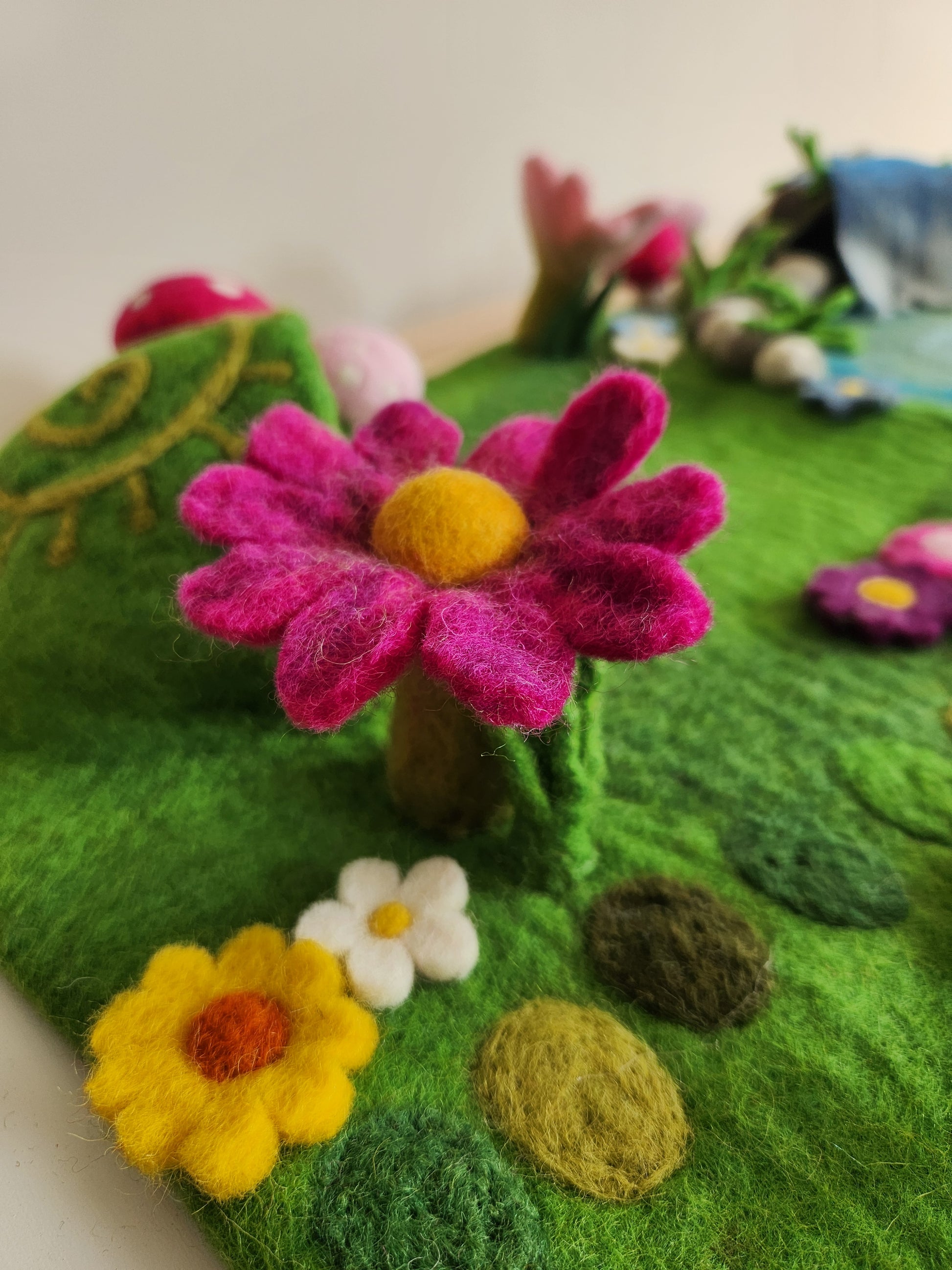 Meadow Falls felt playmat close up view of bright pink flower