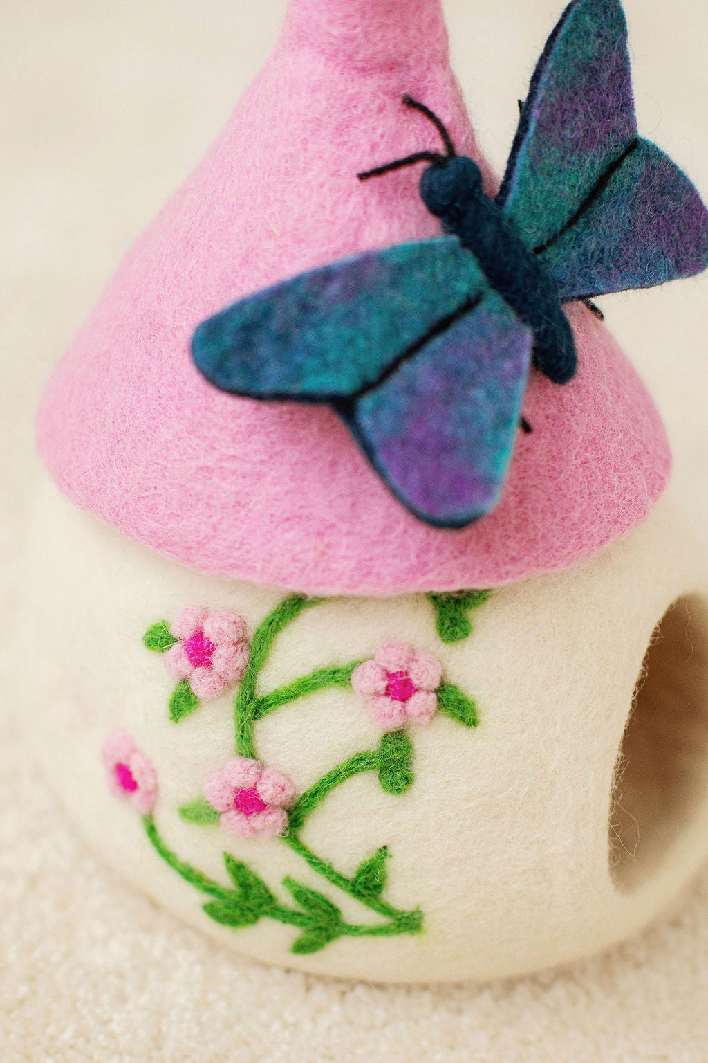 WHITE AND PINK FELT FAIRY HOUSE WITH PINK FLOWER DETAILS AND BLUE BUTTERFLY