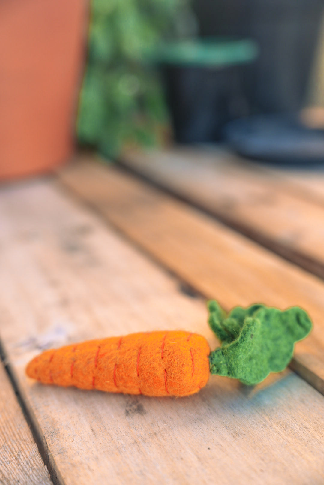 Felt carrot play toy on outdoor garden bench